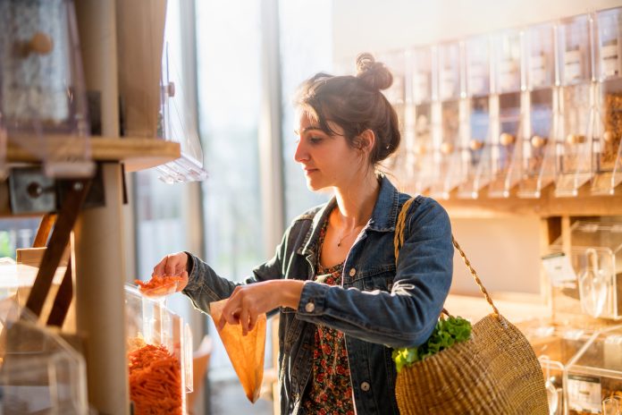 Woman filling sustainable shopping container