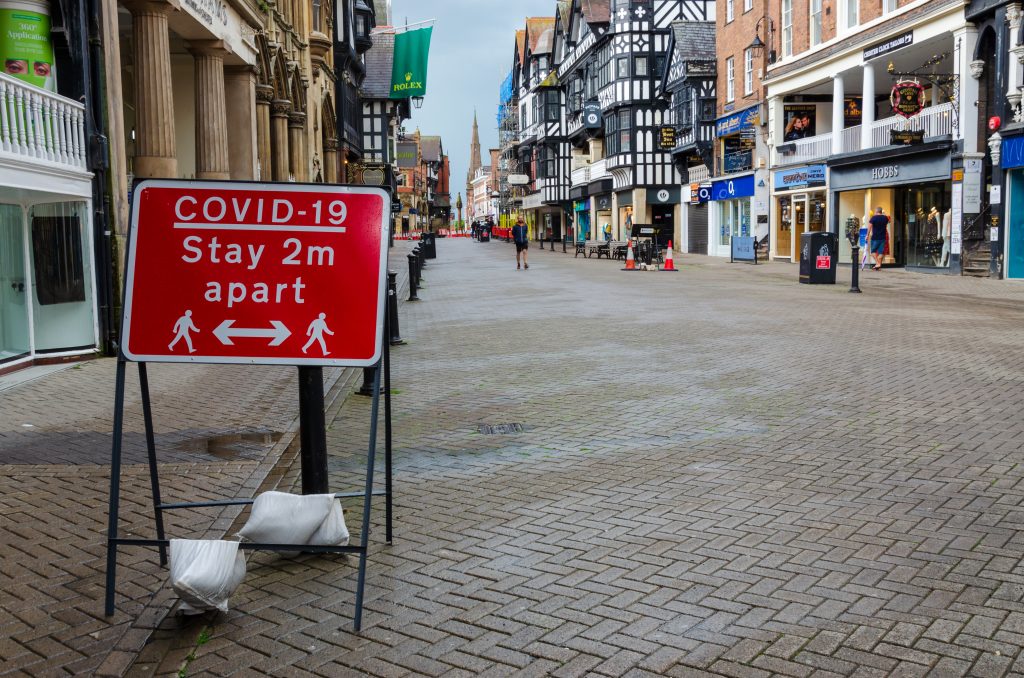 Empty high street with Covid restriction sign