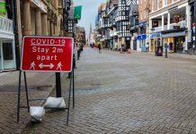 Empty high street with Covid restriction sign