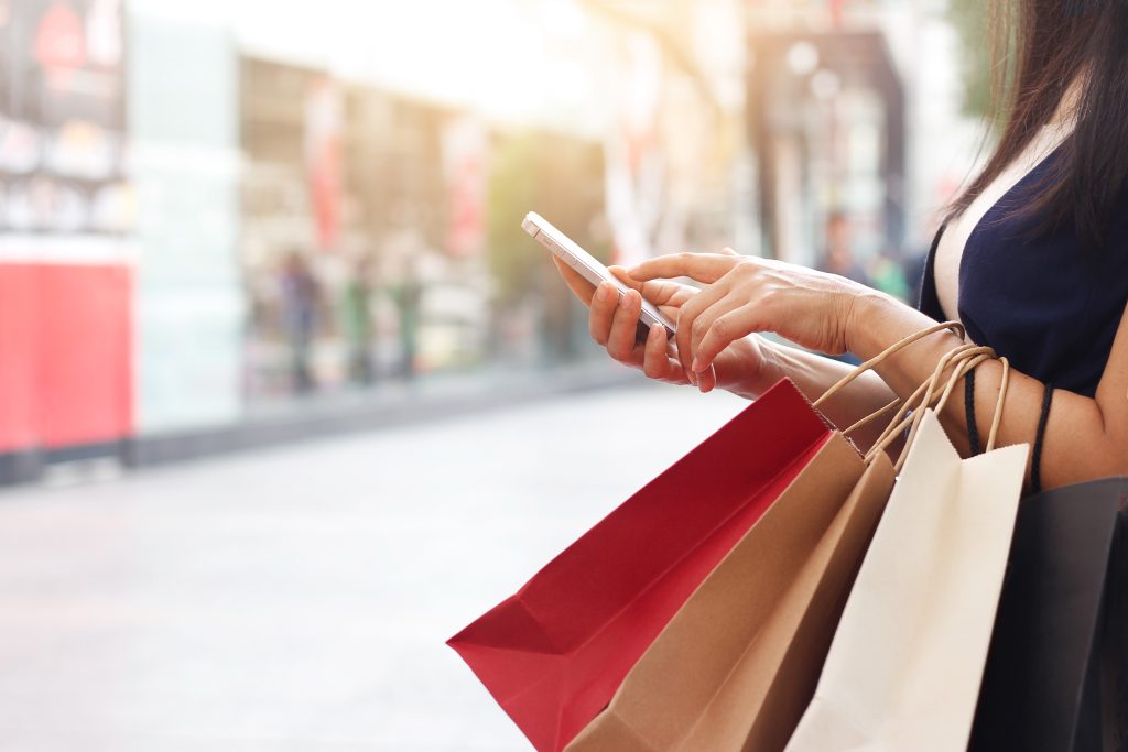 shopping bags and smartphone as online sales sees consumer spend up