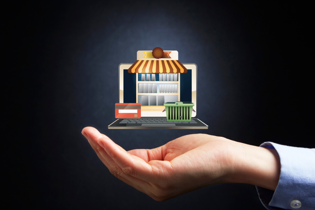 A hand holding a visual of an ecommerce site with a shopping cart and credit card graphic