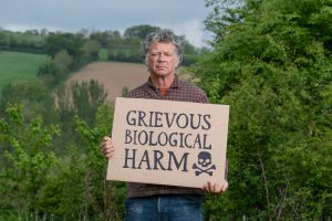 Farmers | image depicting Guy-Singhwatson holding a sign that says 'grevious biloigcal harm'. The founder of organic food company has called for tighter restrictions on glyphosate, arguing the weedkiller has become embedded in Britain’s food system despite mounting public concern over its health and environmental impact.