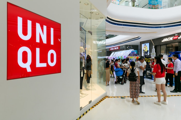 Uniqlo owner Fast Retailing has lowered its annual profit forecast as a result of additional Covid-related government restrictions in Japan and overseas denting footfall.